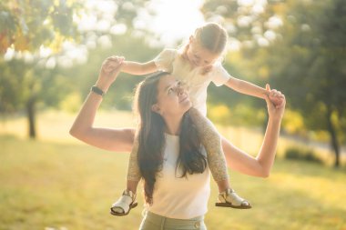 Genç anne ve küçük tatlı kız Prag, Avrupa 'daki sonbahar parkında birlikte eğleniyorlar. Yüksek kalite fotoğraf