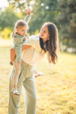 Güzel genç anne ve komik küçük kız Prag, Avrupa 'nın gün batımında sonbahar parkında birlikte eğleniyorlar. Yüksek kalite fotoğraf