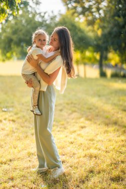 Prag, Avrupa 'daki sonbahar parkında genç bir anne ve küçük tatlı bir kız birlikte oynuyorlar. Yüksek kalite fotoğraf