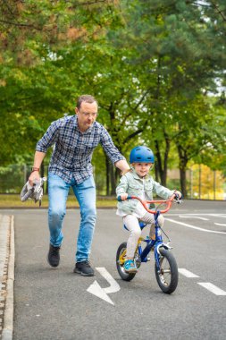 Mutlu aile babası, çocuğa Çek Cumhuriyeti, Avrupa 'da Prag' da bir trafik parkında bisiklet sürmeyi öğretiyor. Yüksek kalite fotoğraf