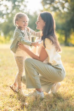 Genç anne ve komik küçük kız Prag, Avrupa 'daki sonbahar parkında birlikte vakit geçiriyorlar. Yüksek kalite fotoğraf