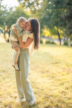 Genç anne ve komik küçük kız Prag, Avrupa 'da sonbahar parkında gün batımında birlikte oynuyorlar. Yüksek kalite fotoğraf
