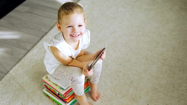Χαμογελαστό Κοριτσάκι Κάθεται Μια Στοίβα Από Παιδικά Παραμύθια Βιβλία Και — Αρχείο Βίντεο