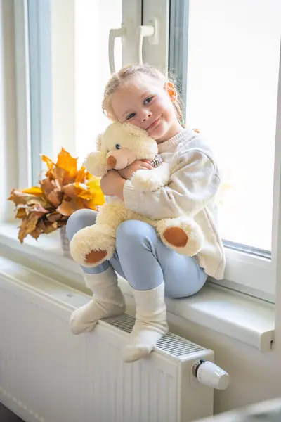 Jolie Petite Fille Pull Chaud Assis Près Fenêtre Avec Petit Images De Stock Libres De Droits