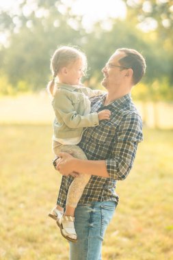 Baba ve komik küçük kızı Prag, Avrupa 'nın gün batımında sonbahar parkında birlikte vakit geçiriyorlar. Yüksek kalite fotoğraf
