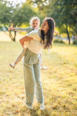 Genç anne ve küçük kızı Prag, Avrupa 'nın gün batımında sonbahar parkında birlikte eğleniyorlar. Yüksek kalite fotoğraf