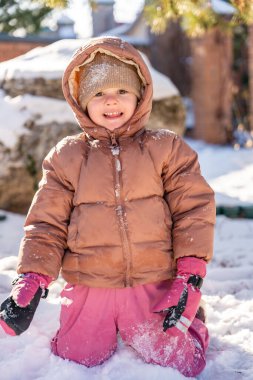 Kışın, Noel zamanı, evin arka bahçesinde karla oynayan bir çocuk. Yüksek kalite fotoğraf