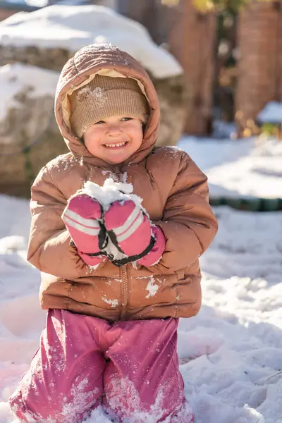 Kışın, Noel zamanı evin arka bahçesinde karla oynayan bir çocuk. Yüksek kalite fotoğraf