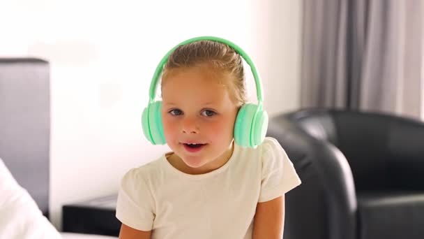 Portrait Little Girl Singing Listening Music Green Kids Headphones Home — Αρχείο Βίντεο