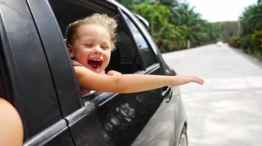 Yolculuk sırasında pencereden dışarı bakan küçük bir kız, çocuk konsepti olan aile gezileri. Yüksek kalite 4k görüntü