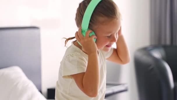 Kislány Érzelmileg Élvezi Zenét Zöld Gyerekek Fejhallgatójával Kiváló Minőségű Felvételek — Stock videók