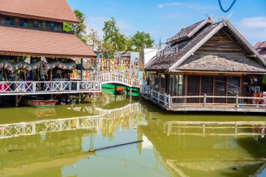 Pattaya, Thailand - December 29, 2023: Floating open air market with small houses - shops on the pond in Pattaya, Thailand. High quality photo