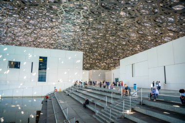 Abu Dabi, BAE - 6 Aralık 2023: Louvre 'un İçi ve Abu Dabi, BAE' deki müze sergilerine bakan ziyaretçiler. Yüksek kalite fotoğraf