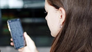 Genç gülümseyen kadın akıllı telefonunda komik bir kitap okuyor. Yüksek kalite 4k görüntü