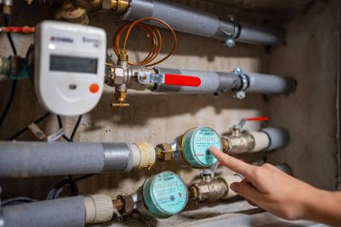 Bir kadın, Avrupa 'daki gerçek evlerdeki soğuk ve sıcak su tüketimini işaret ediyor. Yüksek kalite fotoğraf