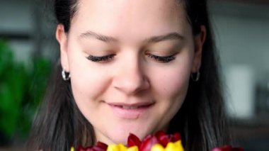 Evinde kırmızı ve sarı lalelerle gülümseyen genç bir kadının portresini yakından çek. Uluslararası Kadınlar Günü 'nü ve Anneler Günü' nü kutlarım. Yüksek kalite 4k görüntü