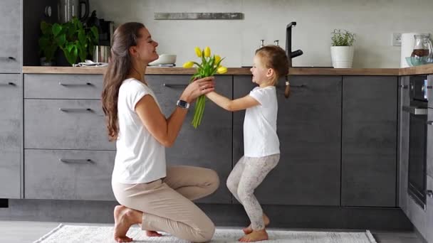 주방에서 엄마에게 노란색 꽃을주는 어머니의 여성의 고품질 — 비디오