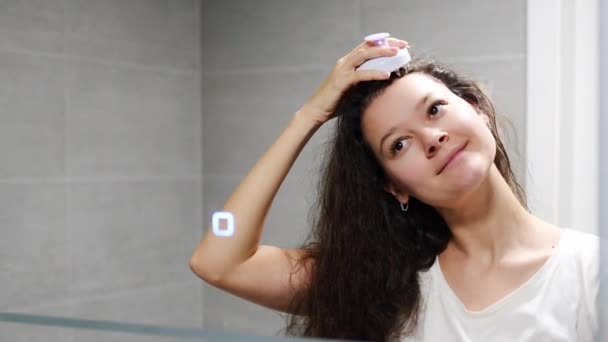 年轻的黑发女子在家里的浴室里用头皮按摩器或毛刷自我按摩头发 以刺激头发生长 反光的镜子 高质量的照片 — 图库视频影像