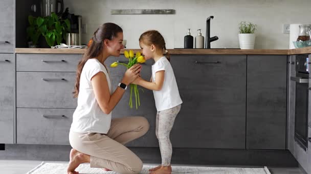 주방에서 엄마에게 노란색 꽃을주는 어머니의 여성의 고품질 — 비디오
