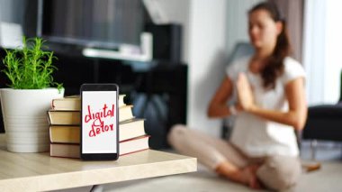 Dijital detoks konsepti. Metni dijital detoks olan akıllı telefon ve arka planda meditasyon yapan kadın. Yüksek kalite 4k görüntü