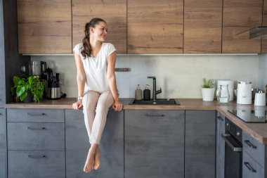 Evde mutfak tezgahında oturan bir kadın. Yüksek kalite fotoğraf