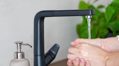 Kadın ellerini yıkıyor ve tekrar kullanılabilir şişeden sabun kullanıyor. Çevre dostu yaşam tarzı. Yüksek kalite 4k görüntü