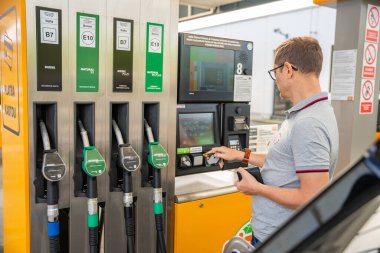 Prag, Çek Cumhuriyeti - 12 Nisan 2024: Adam Avrupa 'daki self-servis benzin istasyonunun terminalinde yakıt için kredi kartıyla ödeme yapıyor. Yüksek kalite fotoğraf