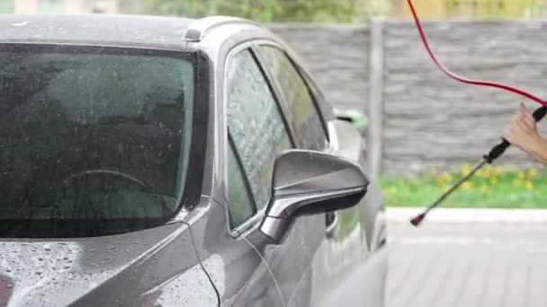 Junger Mann Wäscht Sein Auto Einer Selbstbedienungswaschanlage Mit Einem Schlauch — Stockvideo