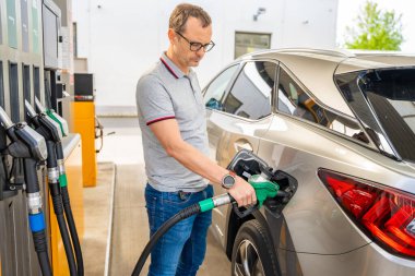 Şoför Avrupa 'daki self servis benzin istasyonunda pahalı benzin dolduruyor. Yüksek kalite fotoğraf