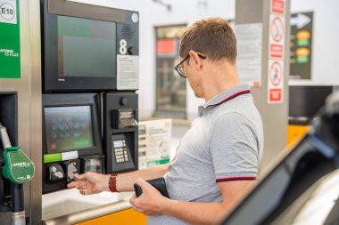 Benzin parasını Avrupa 'daki benzin istasyonu terminalinde kredi kartıyla ödeyen adam. Yüksek kalite fotoğraf