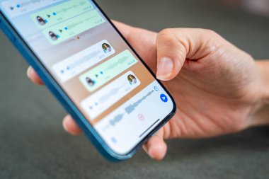 Prag, Çek Cumhuriyeti - 2 Mayıs 2024: Sohbet uygulaması WhatsApp ile iPhone 'u elinde tutan kadın, evdeki sesli mesajlaşma için mobil uygulama kullanıyor. Yüksek kalite fotoğraf