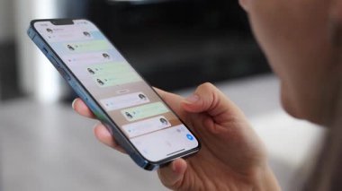Prag, Çek Cumhuriyeti - 2 Mayıs 2024: Sohbet uygulaması WhatsApp ile iPhone 'u elinde tutan kadın, evdeki sesli mesajlaşma için mobil uygulama kullanıyor. Yüksek kalite fotoğraf