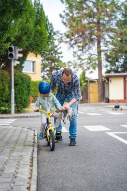 Mutlu aile babası, çocuğa Prag, Çek Cumhuriyeti, Avrupa 'daki bir trafik parkında bisiklet sürmeyi öğretiyor. Yüksek kalite fotoğraf