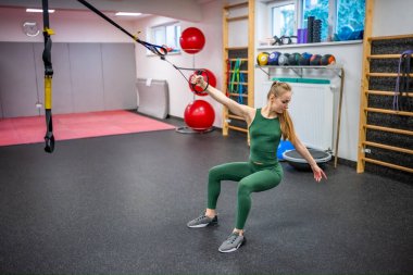 Vücut düzeltmesi için spor salonunda antrenman yapıyorum. Beden eğitiminde spor yapan genç bir kadın. Yüksek kalite fotoğraf