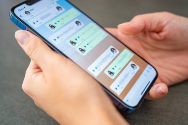 Prag, Çek Cumhuriyeti - 2 Mayıs 2024: Sohbet uygulaması WhatsApp ile iPhone 'u elinde tutan kadın, evdeki sesli mesajlaşma için mobil uygulama kullanıyor. Yüksek kalite fotoğraf