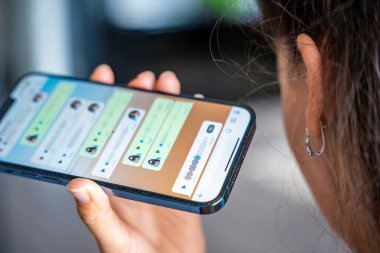 Prag, Çek Cumhuriyeti - 2 Mayıs 2024: Sohbet uygulaması WhatsApp ile iPhone 'u elinde tutan kadın, evdeki sesli mesajlaşma için mobil uygulama kullanıyor. Yüksek kalite fotoğraf