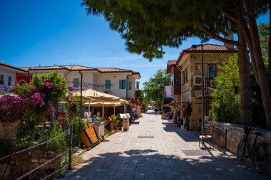Side, Türkiye - 8 Mayıs 2024: Şehir merkezinin sokaklarında insanlar ve Side, Antalya 'da çarşı. Sokak manzaralı kafe, restoran, dükkan ve evler, Türkiye. Yüksek kalite fotoğraf