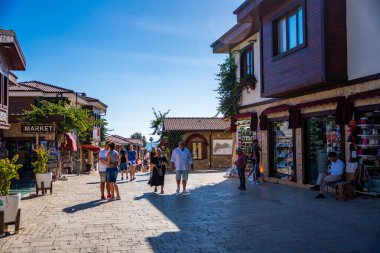 Side, Türkiye - 8 Mayıs 2024: Şehir merkezinin sokaklarında insanlar ve Side, Antalya 'da çarşı. Sokak manzaralı kafe, restoran, dükkan ve evler, Türkiye. Yüksek kalite fotoğraf