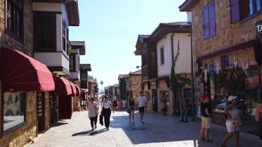 Side, Türkiye - 8 Mayıs 2024: Şehir merkezinin sokaklarında insanlar ve Side, Antalya 'da çarşı. Sokak manzaralı kafe, restoran, dükkan ve evler, Türkiye. Yüksek kalite 4k görüntü