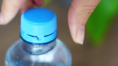 PET şişesinde durgun plastik kapak. Yeni tasarım, kapağın açıldıktan sonra şişeye bağlı kalması ve tüm paketin toplanıp geri dönüşümünün kolaylaştırılması anlamına geliyor. Yüksek kalite 4k görüntü