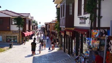 Side, Türkiye - 8 Mayıs 2024: Şehir merkezinin sokaklarında insanlar ve Side, Antalya 'da çarşı. Sokak manzaralı kafe, restoran, dükkan ve evler, Türkiye. Yüksek kalite 4k görüntü