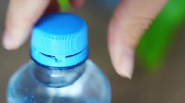 PET şişesinde durgun plastik kapak. Yeni tasarım, kapağın açıldıktan sonra şişeye bağlı kalması ve tüm paketin toplanıp geri dönüşümünün kolaylaştırılması anlamına geliyor. Yüksek kalite 4k görüntü
