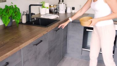 Geri dönüşüm için mutfakta atık ayıklamak için çöpleri evdeki çöp kutularına atan bir kadın. Plastik, kağıt, biyolojik ve karışık atık. Ev konseptinde atık ayıklama. Yüksek kalite 4k görüntü