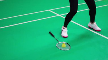 Raket ve mekik aletli genç bayan badminton oynamadan önce antrenman yapıyor, ısınıyor. Yüksek kalite 4k görüntü