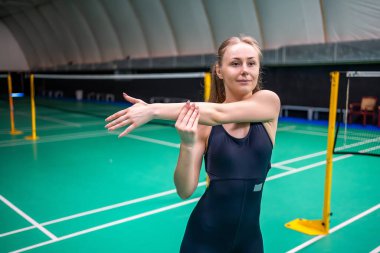 Raket ve mekik aletli genç bayan badminton oynamadan önce antrenman yapıyor, ısınıyor. Yüksek kalite fotoğraf