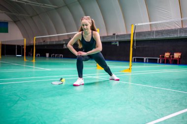 Raket ve mekik aletli genç bayan badminton oynamadan önce antrenman yapıyor, ısınıyor. Yüksek kalite fotoğraf