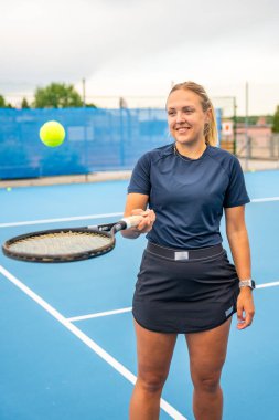 Profesyonel bayan tenisçi tenis raketi ve top ile dışarıda poz veriyor. Yüksek kalite fotoğraf