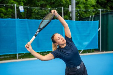 Profesyonel bayan tenisçi tenis kortunun dışında oynamadan önce tenis raketiyle ısınıyor. Yüksek kalite fotoğraf