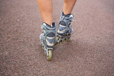 Patenci kadının paten kayışını yakından görebiliyoruz. Parkta paten kayarken. Açık hava aktiviteleri. Yaz pateni. Yüksek kalite fotoğraf