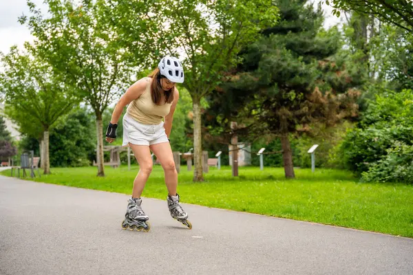Parktaki patenci kadın paten kayıyor, paten kayıyor. Açık hava aktiviteleri. Yaz pateni. Yüksek kalite fotoğraf